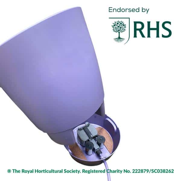 Lila Pflanzgefäß mit einem sichtbaren, im Sockel integrierten Bewässerungsmechanismus, einem daran befestigten Kabel und einem RHS-Logo „Endorsed by“ in der oberen rechten Ecke.